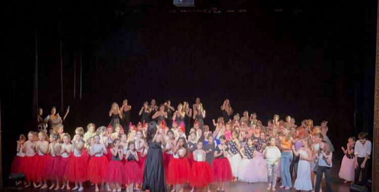 Spectacle de fin d'année : Mishell et ses élèves saluant sur scène en tutus rouges